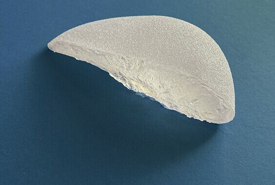Foto eines durchgeschnittenen Brustimplantats mit texturierter Oberfläche. Der Querschnitt zeigt das Innere des Implantats mit transparentem Silikongel.